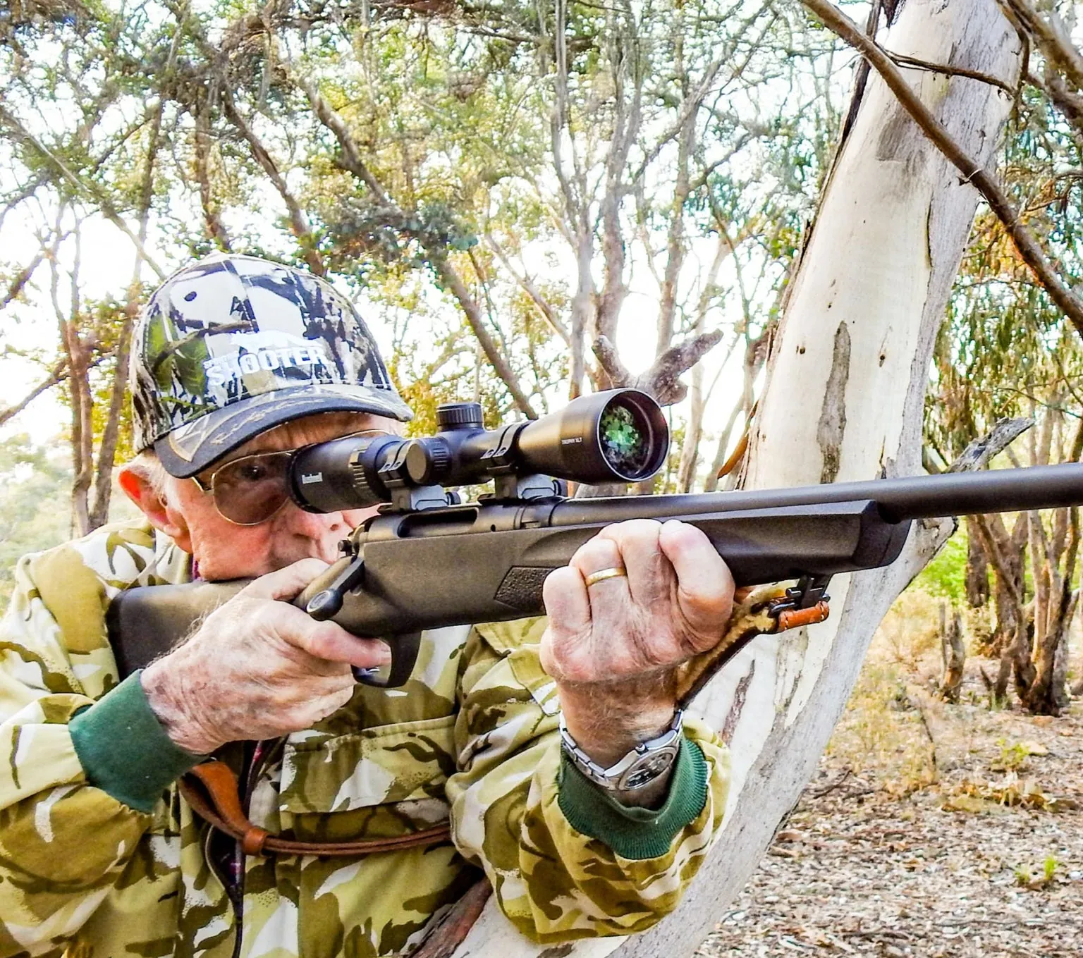 A hunter in camouflage aiming a scoped Remington 783 rifle
